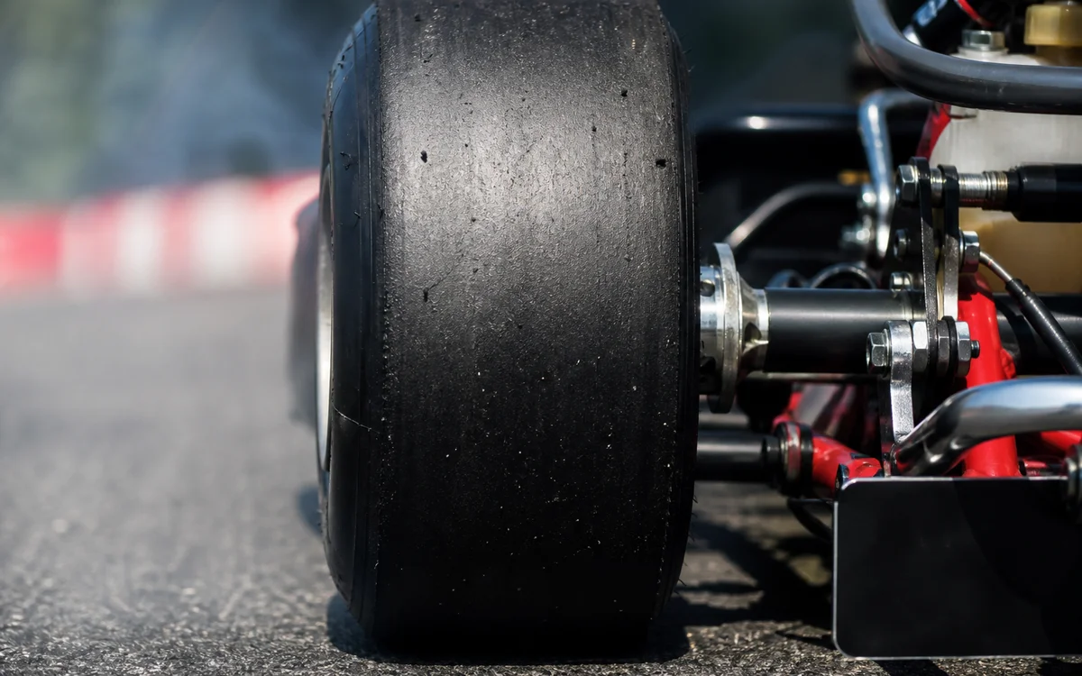 Detalle de neumático slick de kart sobre asfalto de pista